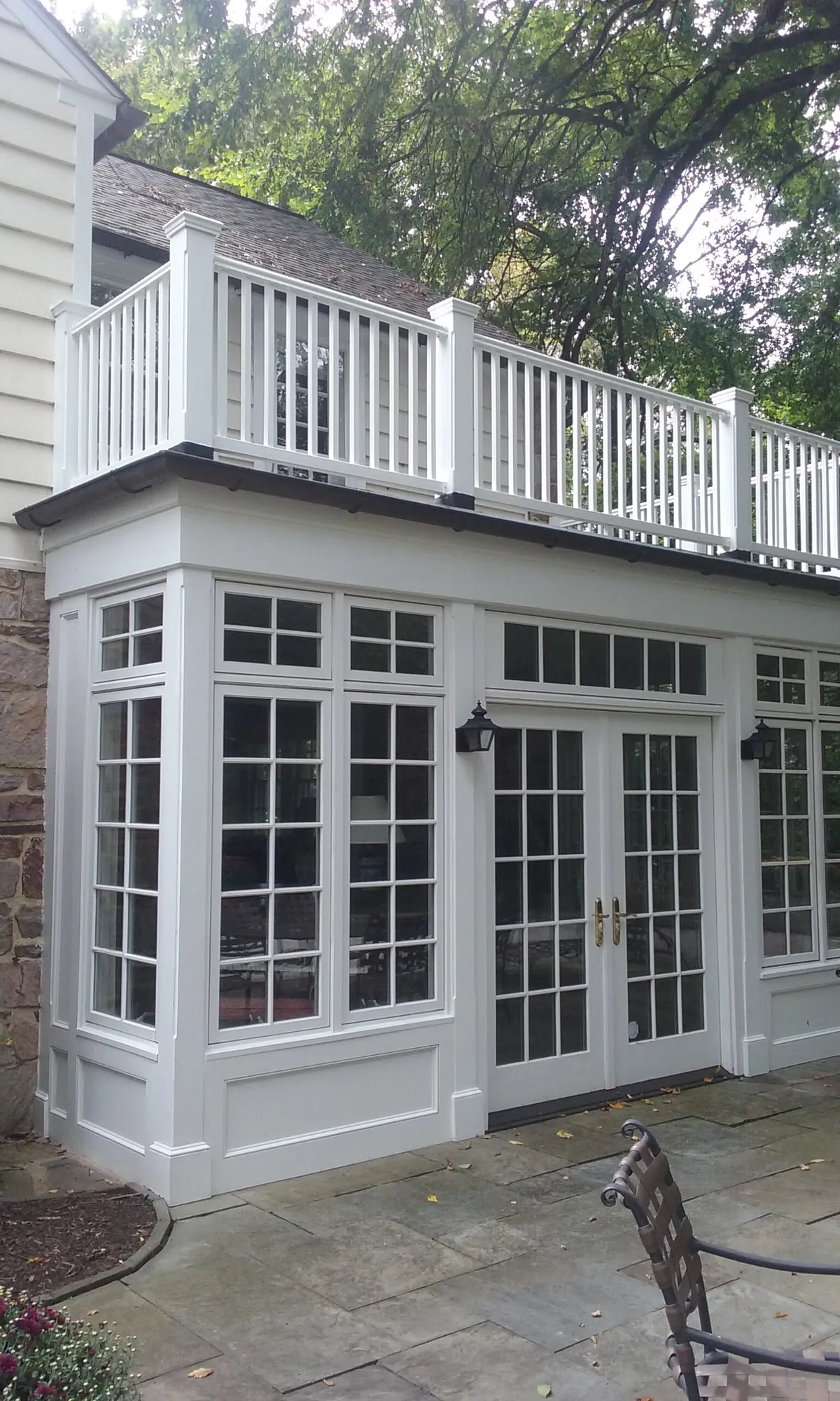 Sunroom addition with a balcony railing