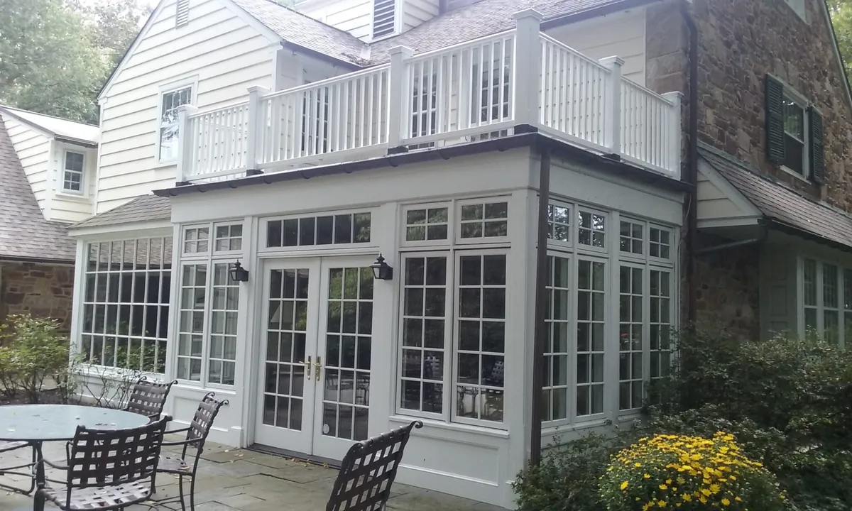 Sunroom addition with a second-floor balcony