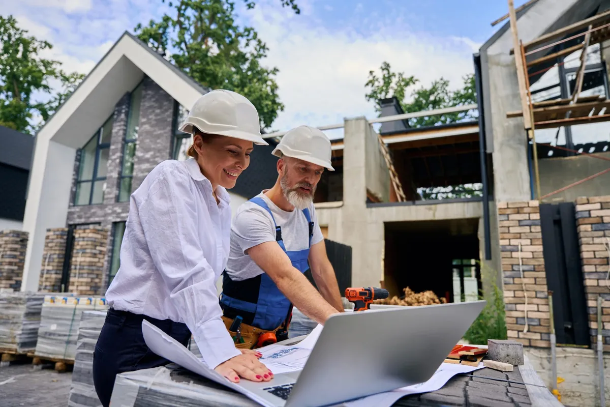 Builders reviewing architectural plans on site